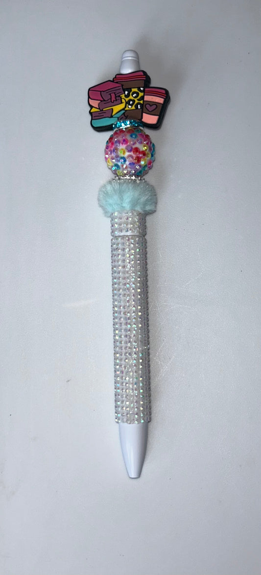 Decorative pen with colorful top and gemstone accents on a white background